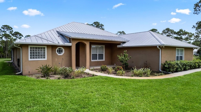 single story home featuring stucco siding, metal roof, and a front yard