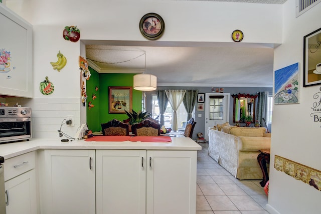 kitchen with white cabinets, pendant lighting, light tile floors, and a textured ceiling