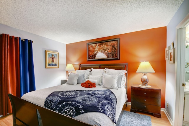 bedroom with a textured ceiling and light hardwood / wood-style floors