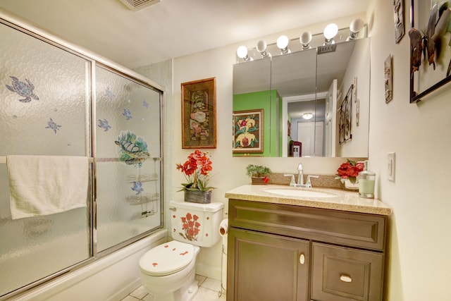 full bathroom with tile flooring, bath / shower combo with glass door, vanity with extensive cabinet space, and toilet