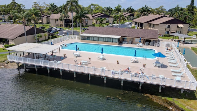 view of swimming pool featuring a patio area and a water view