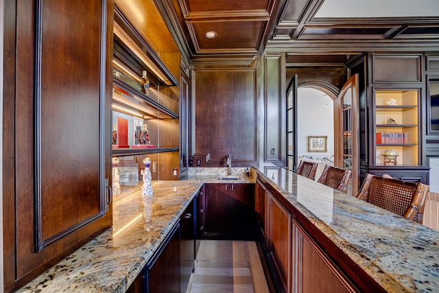 bar with crown molding, coffered ceiling, and light stone counters