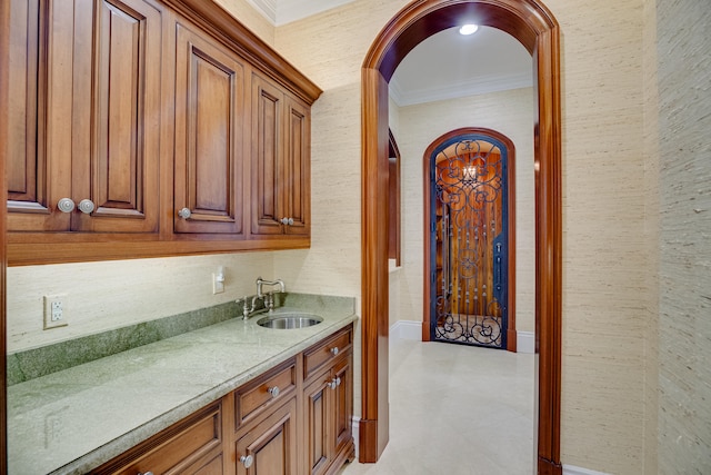 kitchen featuring ornamental molding, light tile floors, and sink