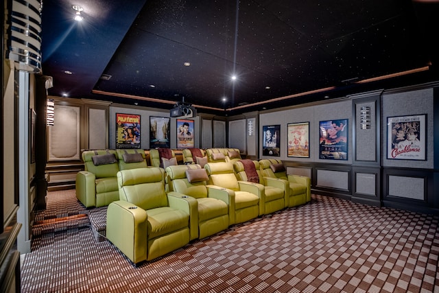 carpeted home theater room featuring a tray ceiling