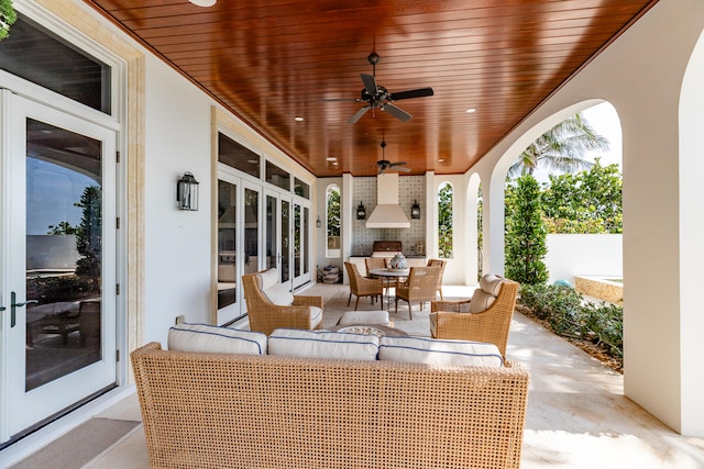 view of patio with an outdoor living space with a fireplace and ceiling fan