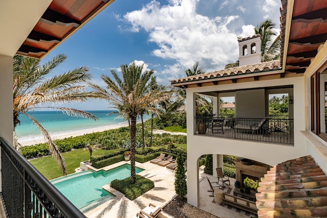 exterior space with a water view, a patio, and a view of the beach