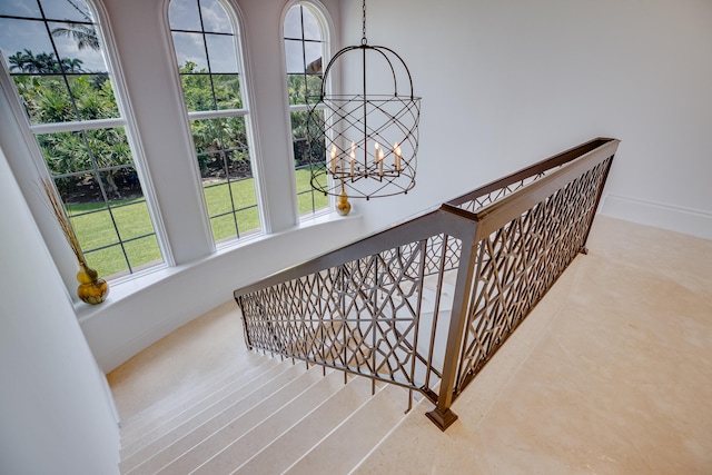 stairs featuring a notable chandelier and a towering ceiling