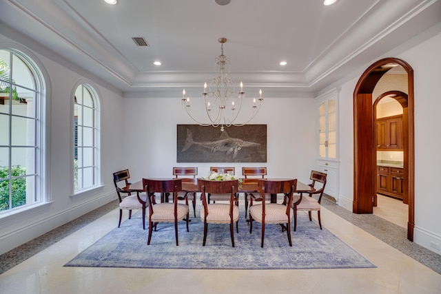 dining room with a chandelier, a raised ceiling, and light tile floors