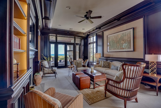 sitting room with crown molding, light colored carpet, and ceiling fan