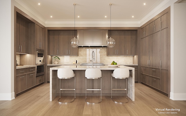 kitchen featuring tasteful backsplash, an island with sink, light hardwood / wood-style floors, and pendant lighting