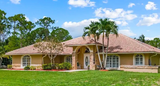 mediterranean / spanish home with a front yard