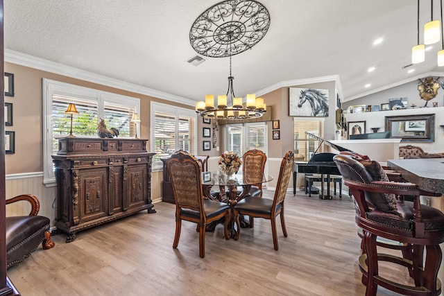 dining room featuring light hardwood / wood-style floors, an inviting chandelier, and ornamental molding