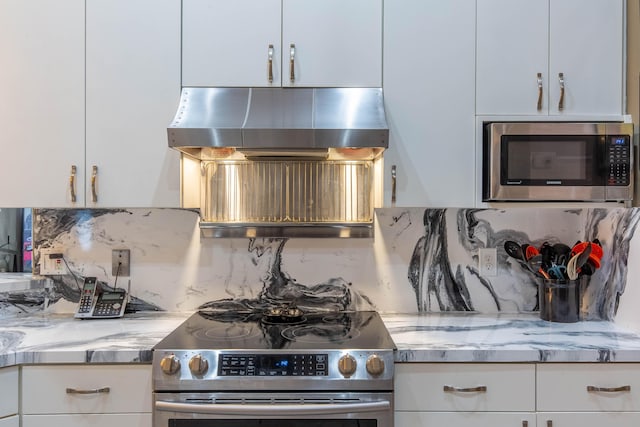2559 Palm Deer Dr, Loxahatchee, FL 33470 - kitchen with appliances with stainless steel finishes, range hood, tasteful backsplash, white cabinetry, and light stone countertops