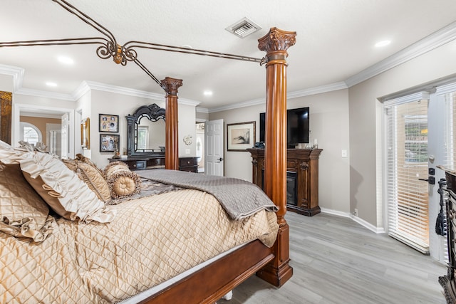 bedroom featuring decorative columns, light hardwood / wood-style flooring, and ornamental molding