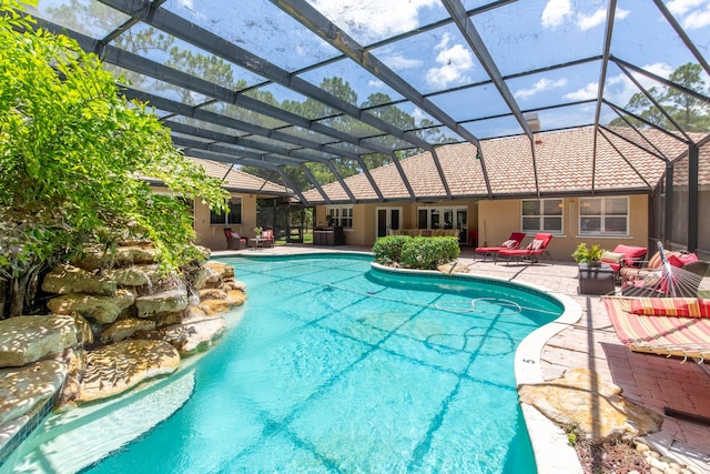 view of swimming pool with glass enclosure and a patio