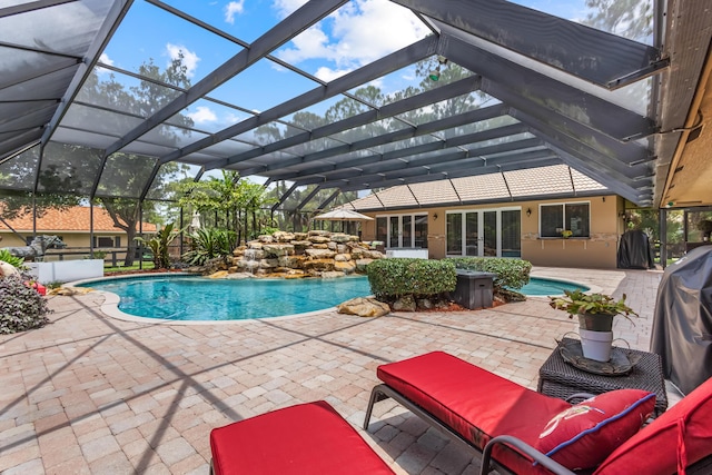 view of pool with a lanai, a patio area, and grilling area