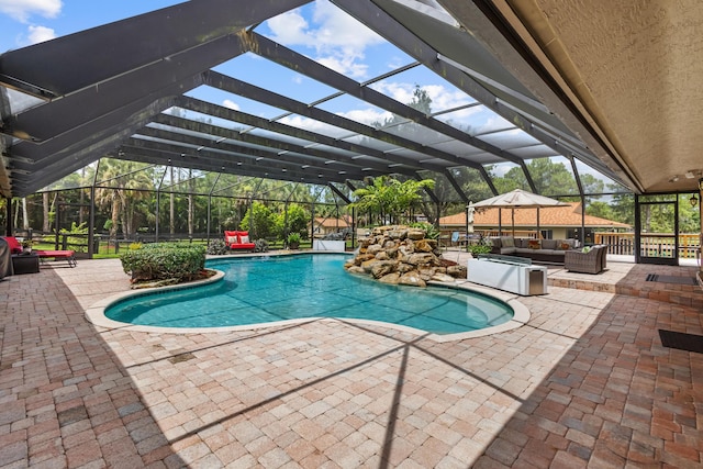 view of swimming pool featuring outdoor lounge area, a lanai, and a patio area