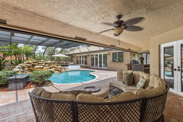 view of swimming pool with french doors, an outdoor living space, ceiling fan, glass enclosure, and a patio