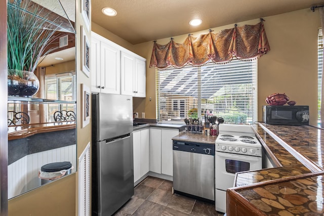 kitchen featuring white cabinets, stainless steel appliances, and a textured ceiling