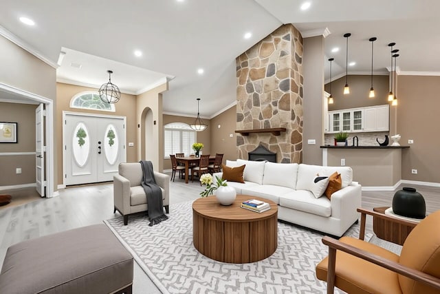 2559 Palm Deer Dr, Loxahatchee, FL 33470 - living room featuring crown molding, light wood finished floors, arched walkways, baseboards, and recessed lighting