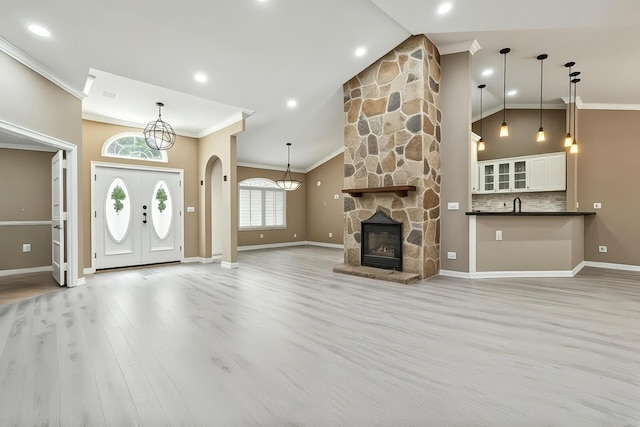 2559 Palm Deer Dr, Loxahatchee, FL 33470 - unfurnished living room with ornamental molding, arched walkways, baseboards, light wood-type flooring, and high vaulted ceiling