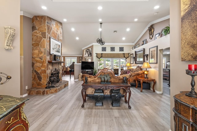 2559 Palm Deer Dr, Loxahatchee, FL 33470 - living room with crown molding, a stone fireplace, light wood-style floors, high vaulted ceiling, and baseboards
