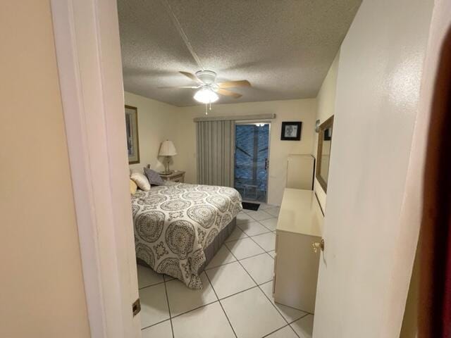 bedroom featuring a textured ceiling, light tile flooring, and ceiling fan