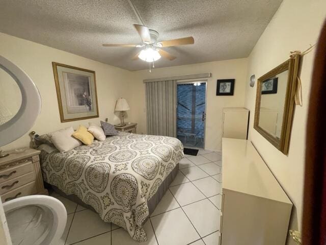 bedroom with a textured ceiling, ceiling fan, and light tile floors