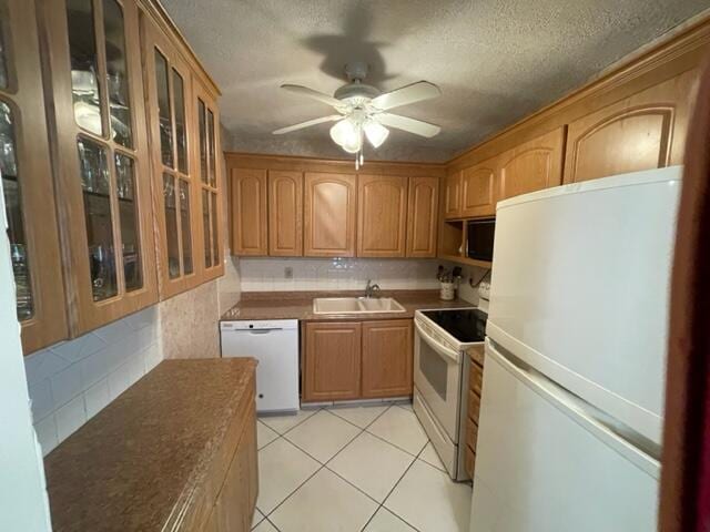 kitchen with light tile flooring, ceiling fan, white appliances, backsplash, and sink