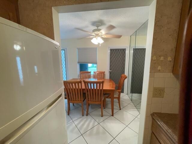 dining room featuring ceiling fan and light tile flooring