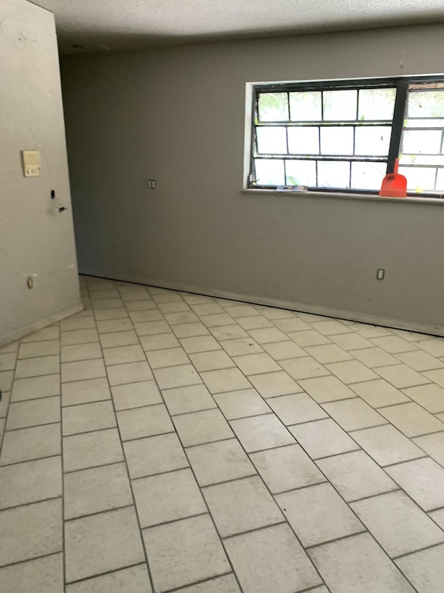 unfurnished room with a textured ceiling