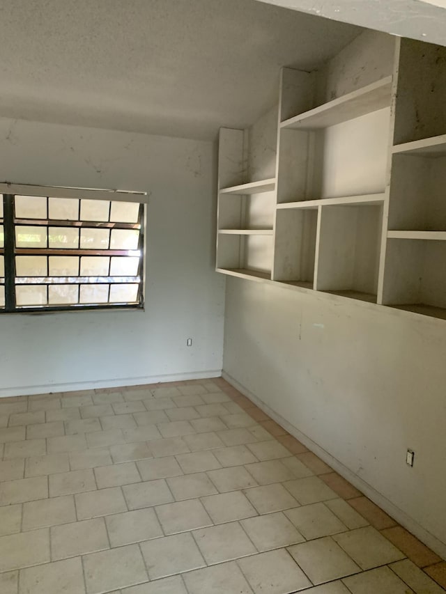 unfurnished room with tile patterned floors and a textured ceiling