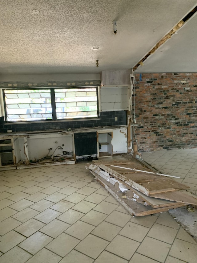 kitchen with brick wall and a textured ceiling