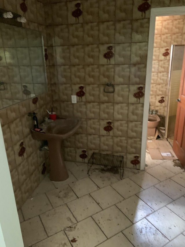 bathroom with toilet and tile walls