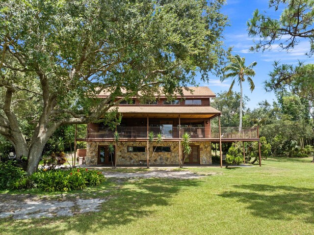 rear view of property featuring a yard and a wooden deck