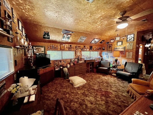 interior space with a textured ceiling, vaulted ceiling, ceiling fan, and carpet floors