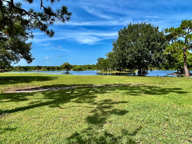 view of home's community featuring a lawn and a water view