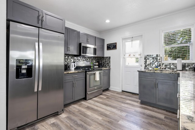 422 49th St, West Palm Beach, FL 33407 - kitchen featuring appliances with stainless steel finishes, crown molding, a sink, tasteful backsplash, and light stone counters