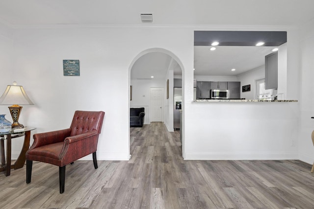 422 49th St, West Palm Beach, FL 33407 - kitchen featuring gray cabinets, stainless steel appliances, arched walkways, wood finished floors, and ornamental molding