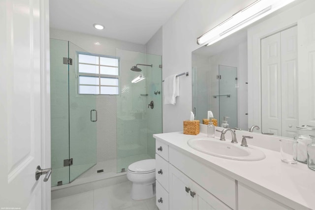 bathroom featuring a shower with shower door, tile flooring, large vanity, and toilet