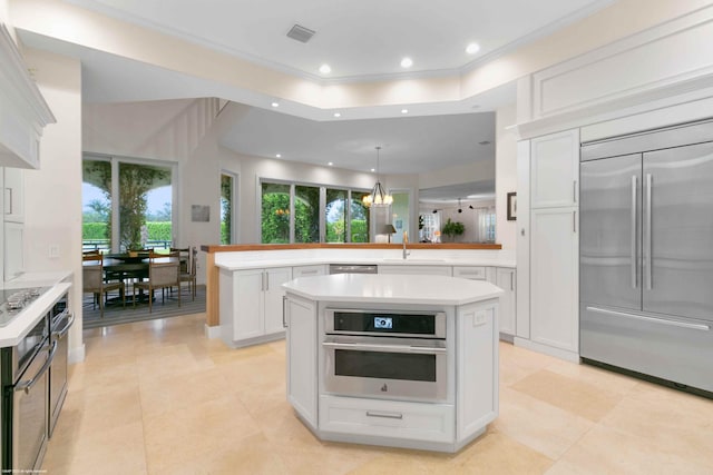 kitchen featuring plenty of natural light, a kitchen island, white cabinets, and appliances with stainless steel finishes