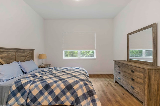 bedroom featuring multiple windows and light wood-type flooring