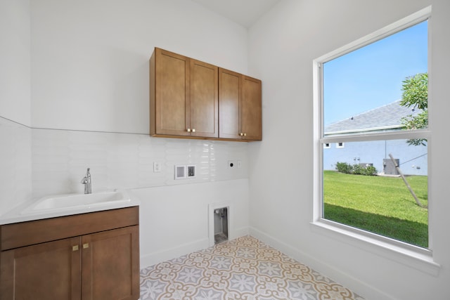 washroom with light tile floors, cabinets, sink, washer hookup, and hookup for an electric dryer