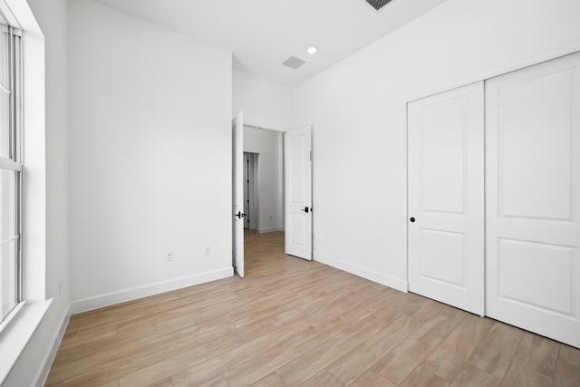 unfurnished bedroom featuring a closet and light wood-type flooring