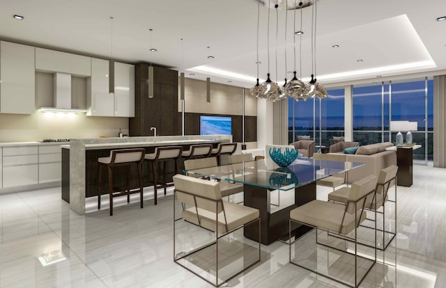 dining room featuring a chandelier, a tray ceiling, and light tile flooring