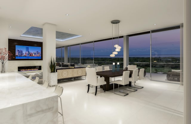 tiled dining room featuring expansive windows and a notable chandelier