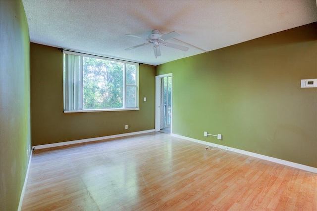 empty room with a textured ceiling, light hardwood / wood-style flooring, and ceiling fan