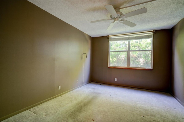 unfurnished room featuring light colored carpet, a textured ceiling, and ceiling fan