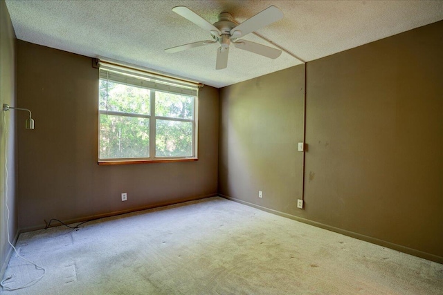 carpeted spare room with a textured ceiling and ceiling fan