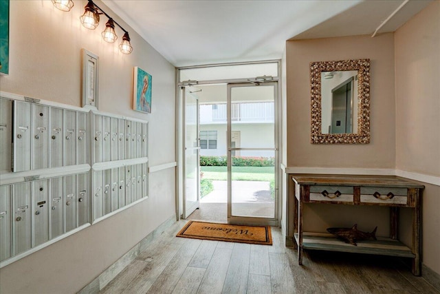 entryway with wood-type flooring and a mail area